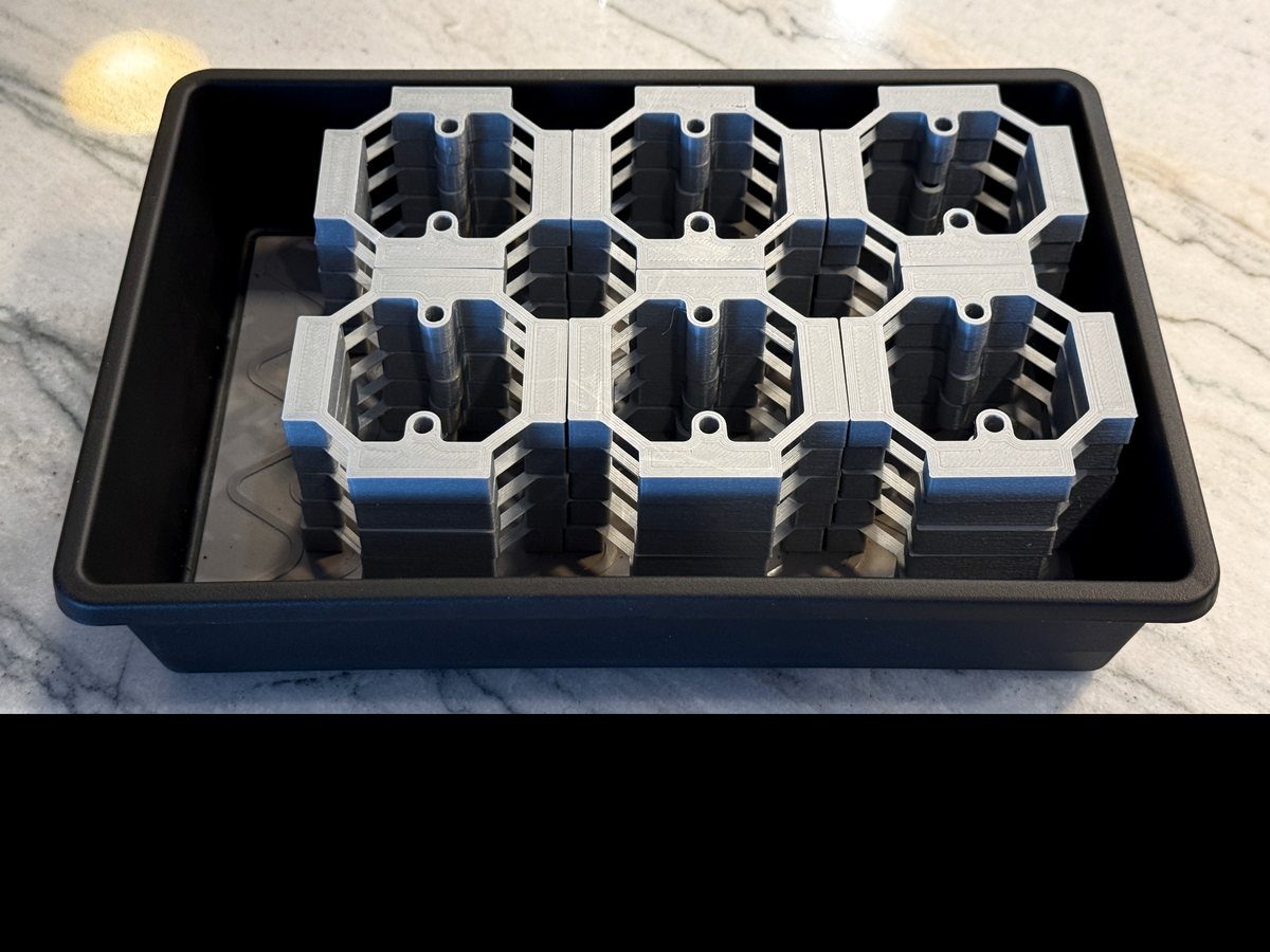 A tray of printed lamp frame rings stacked in production quantity