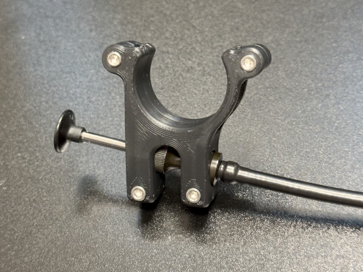 A printed handlebar clamp holding a cable release, closed with four stainless screws