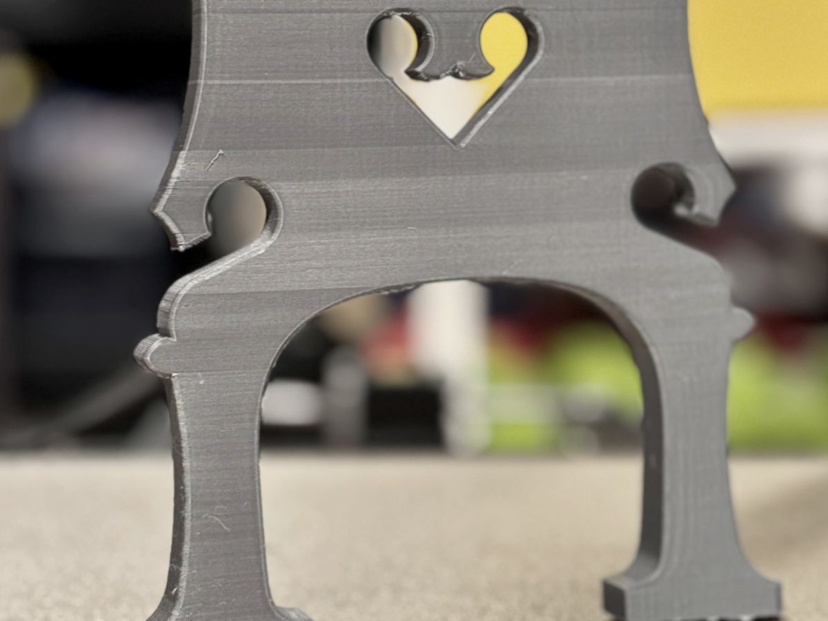 A printed bass bridge with holes along the top to carry neon tubing